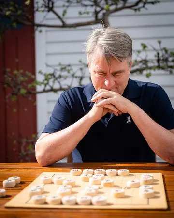 Paul English 在棋盘前继续摆棋